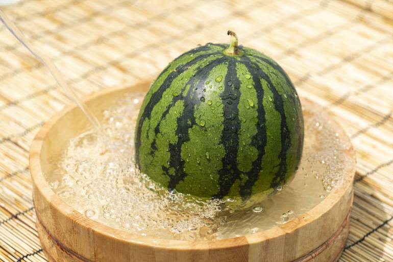 Cool the watermelon with cold water. Japanese summer scene.
