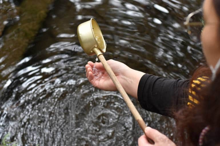 woman purifies herself before going to maruike pond